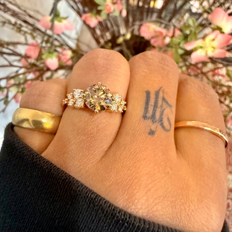 Natural champagne diamond engagement ring shown on hand with white diamond accents in cluster style set in rose gold and handmade in nyc by custom jewelry designer, Dana Walden Chin 